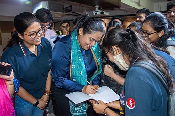 Mahasweta Chakraborty giving autographs to students at Sister Nivedita University.   
