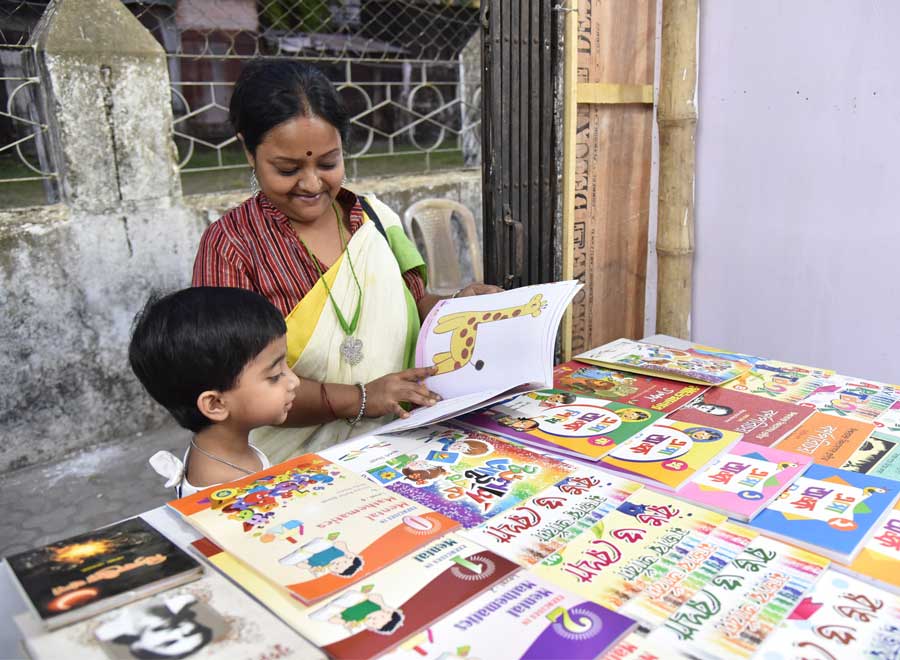A child and his ward browse through colouring books at a fair on Friday