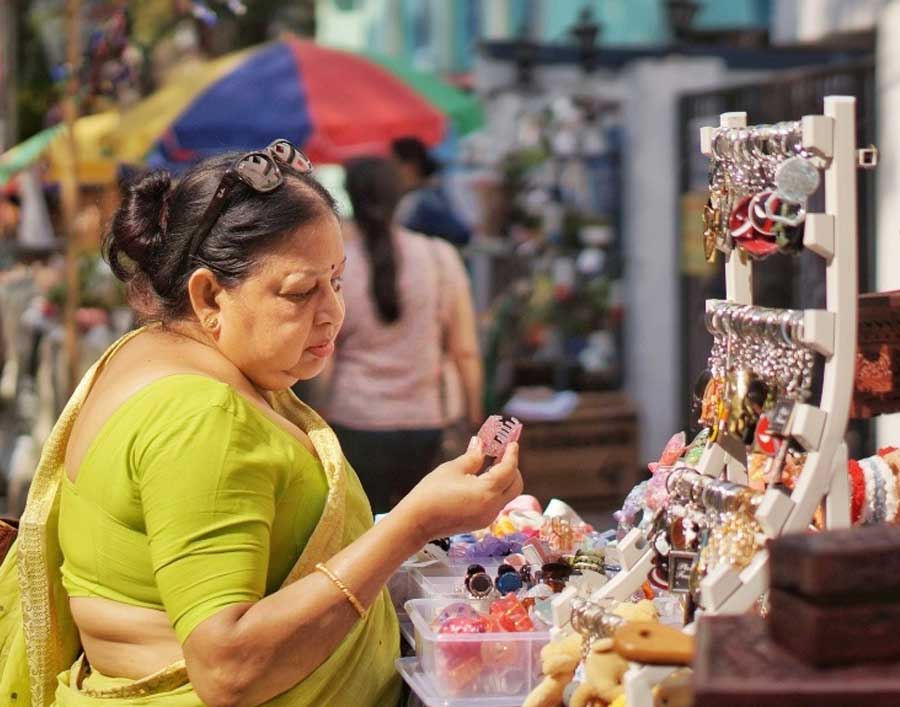 A woman browses through different products at a stall for hand-made jewellery and other accessories