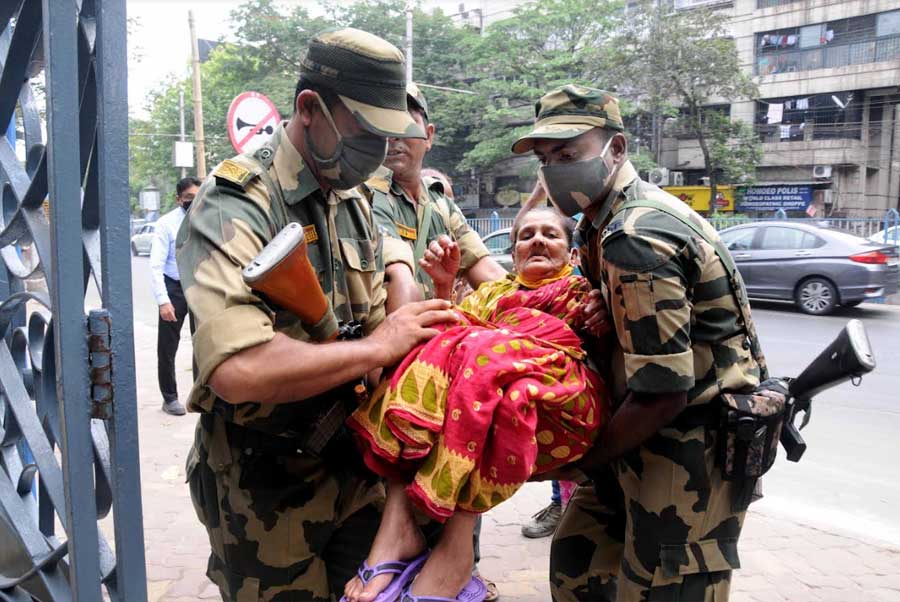 Border Security Force personnel help an elderly woman reach the polling booth in Ballygunge on Tuesday. The by-elections in Ballygunge Assembly and Asansol Lok Sabha constituencies were held on Tuesday. Results for the bypolls will be declared on April 16