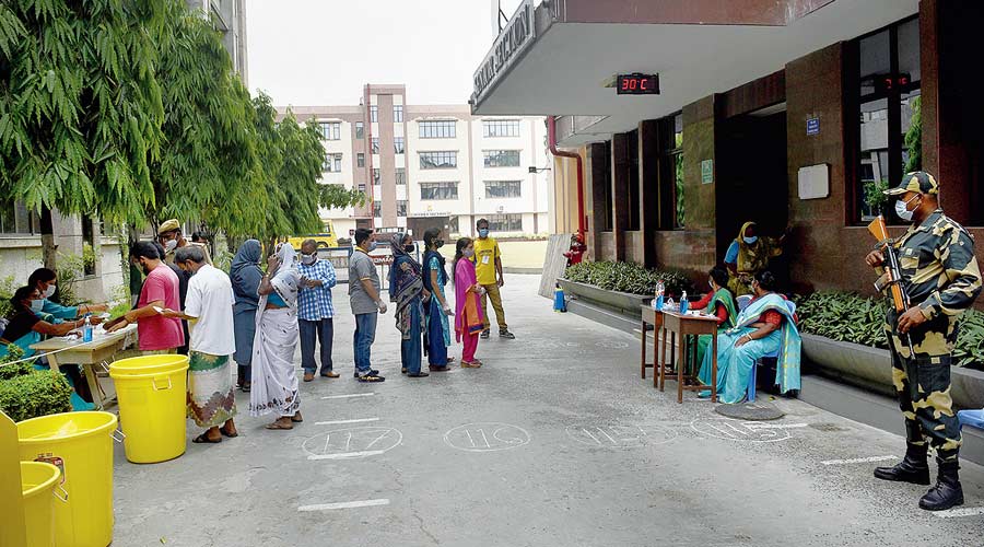 Voters queue up at a polling station at Mahadevi Birla World Academy in Calcutta on Tuesday.