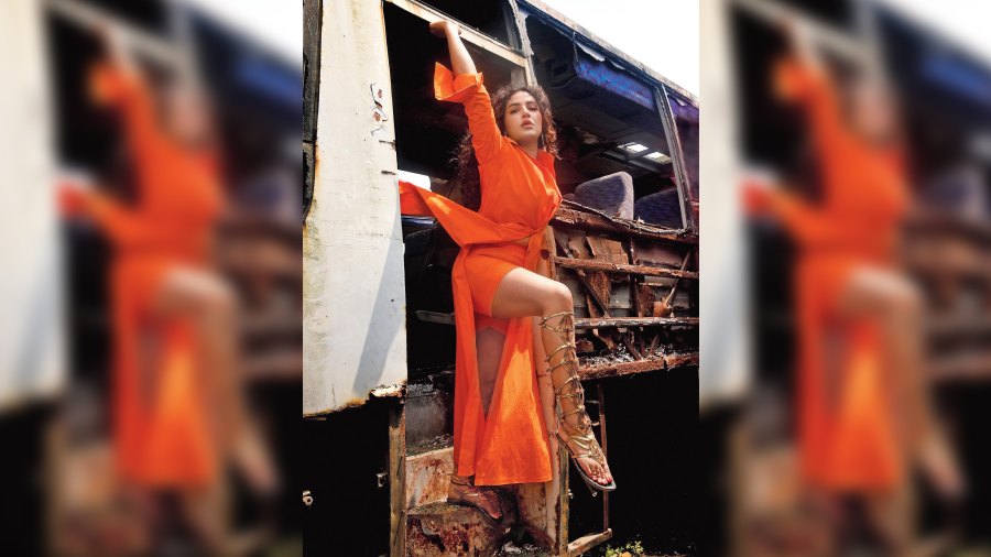 With the afternoon sun beating down on Subhashree and the whole team, the Parineeta actor posed in this derelict bus, stationed in the middle of a Rajarhat expanse, dangerously strewn with glass shards and protruding metal parts of the bus. “The location and the colour of the costume were the highlights for me. The make-up and hair were also different,” she said. Subhashree sported a Mehek Talreja tangerine co-ord set complemented by voluminous curls + sunset eyes + glossy-tinted lips + metallic gladiator sandals. 