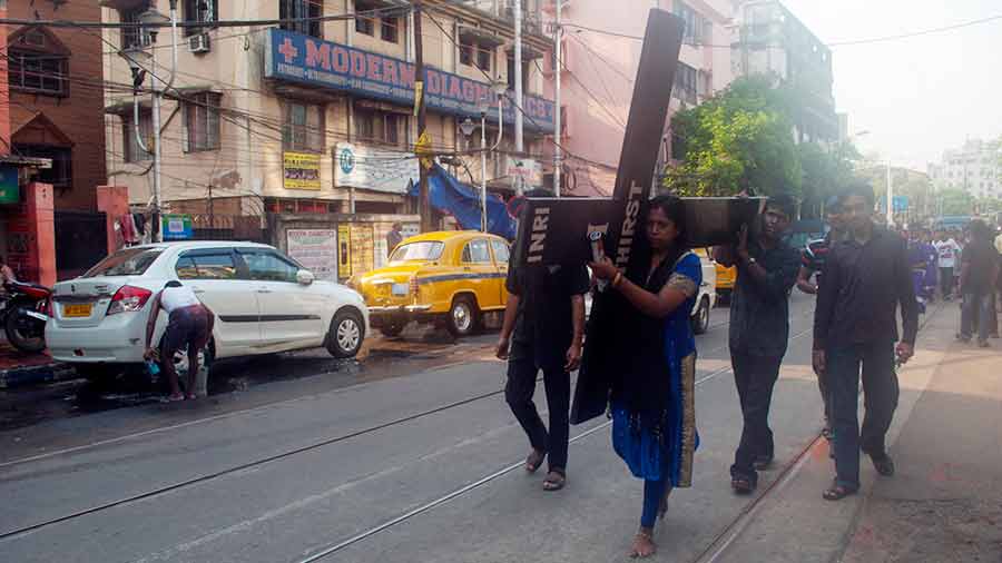 A woman carries the Cross along Rafi Ahmed Kidwai Road 