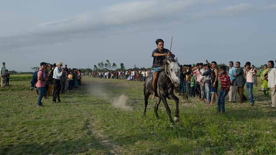 Crowds cheer as horse and rider gallops past them