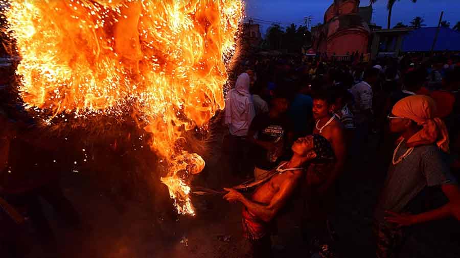 Many daredevil acts — including rituals with fire — are seen at the Charak Gajan melas