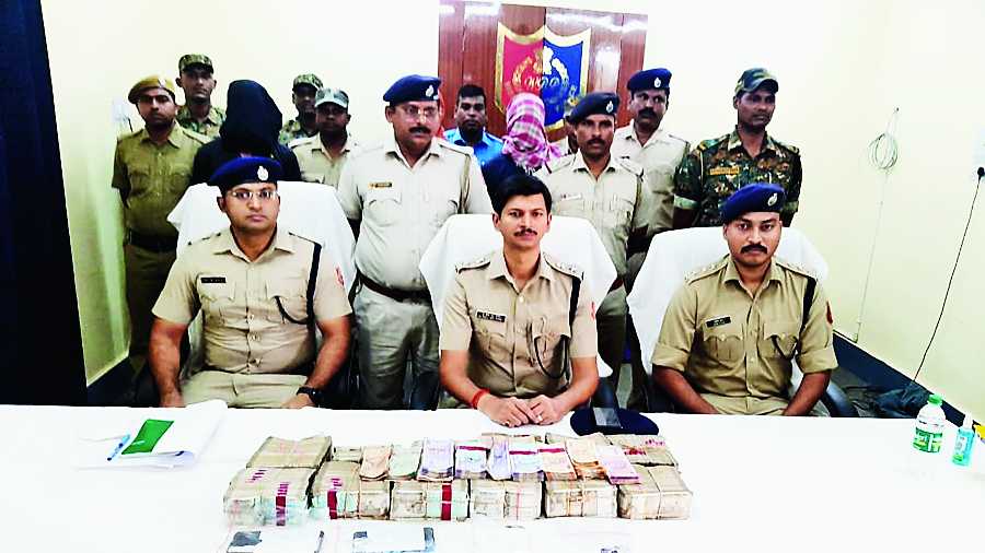 Cops with the recovered cash on Thursday.