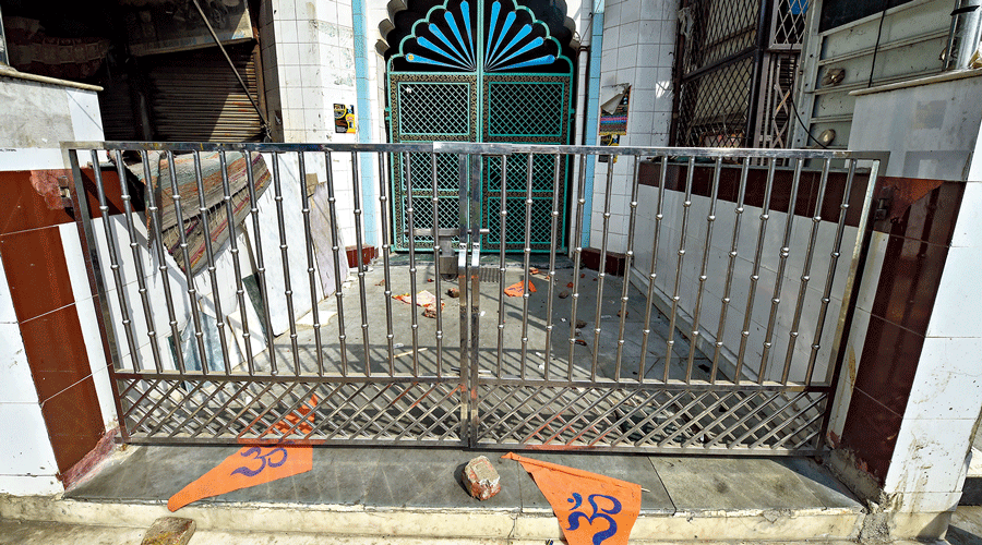 Saffron flags and brickbats lie at the entrance and on the premises of a mosque at Jahangirpuri in New Delhi on Sunday.