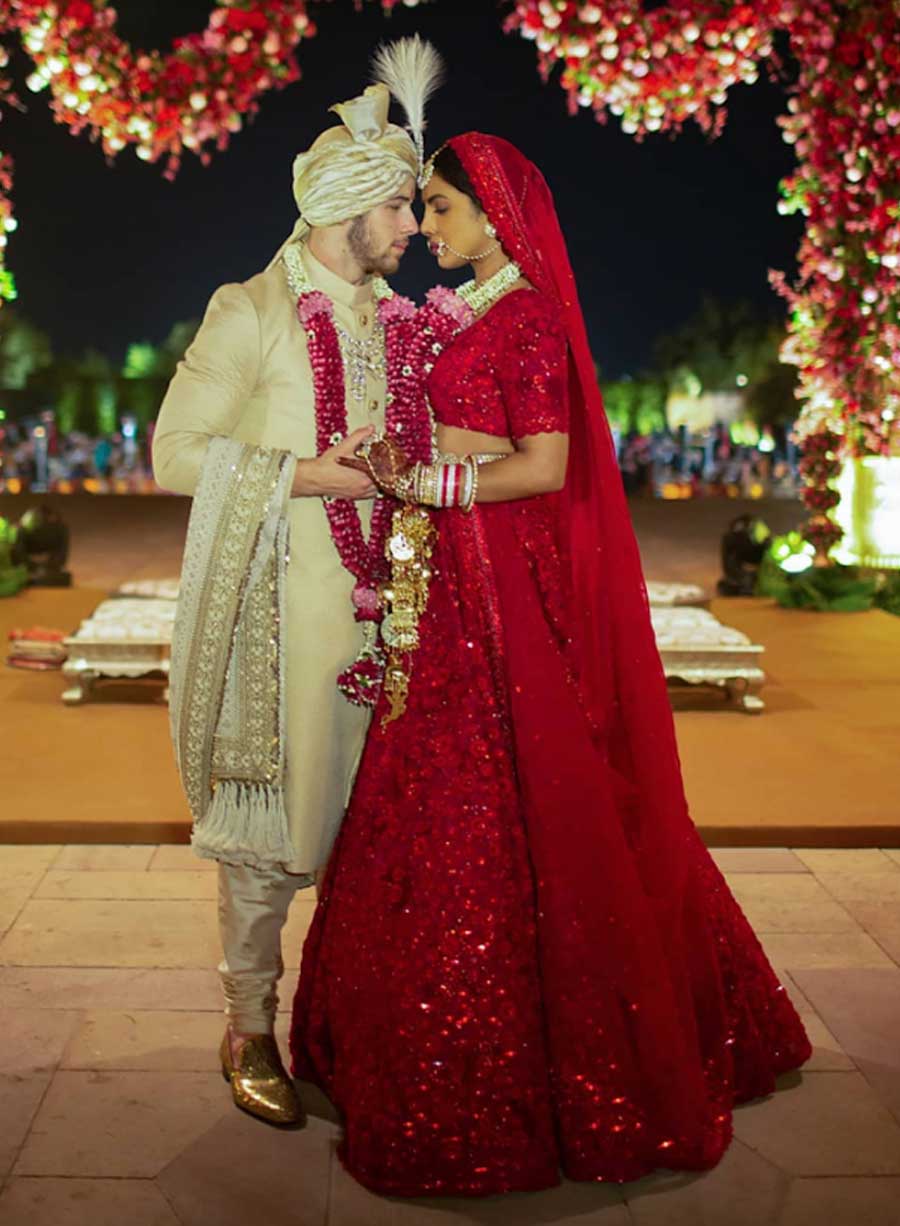 Priyanka Chopra: The ‘Desi Girl’ chose a breathtaking vermillion red lehenga made by 110 embroiderers from Kolkata. The hand-cut organza flowers, French knots in silk floss, delicate Siam-red crystals and layer upon layer of thread-work embroidery needed 3,720 hours of artisanship