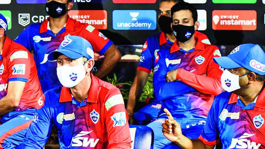 Delhi Capitals coaches Ricky Ponting and Ajit Agarkar (left) wear masks in the team dugout on Wednesday.