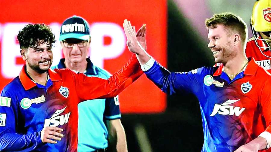 Kuldeep Yadav (left) of Delhi Capitals celebrates with David Warner after taking one of his two Punjab Kings wickets.