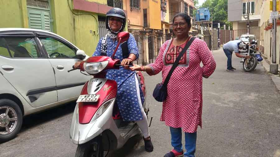 Babita Goswami, or Bobby Didi (right), teaches a girl how to ride a scooter, down Rupchand Mukherjee Lane in Bhowanipore 