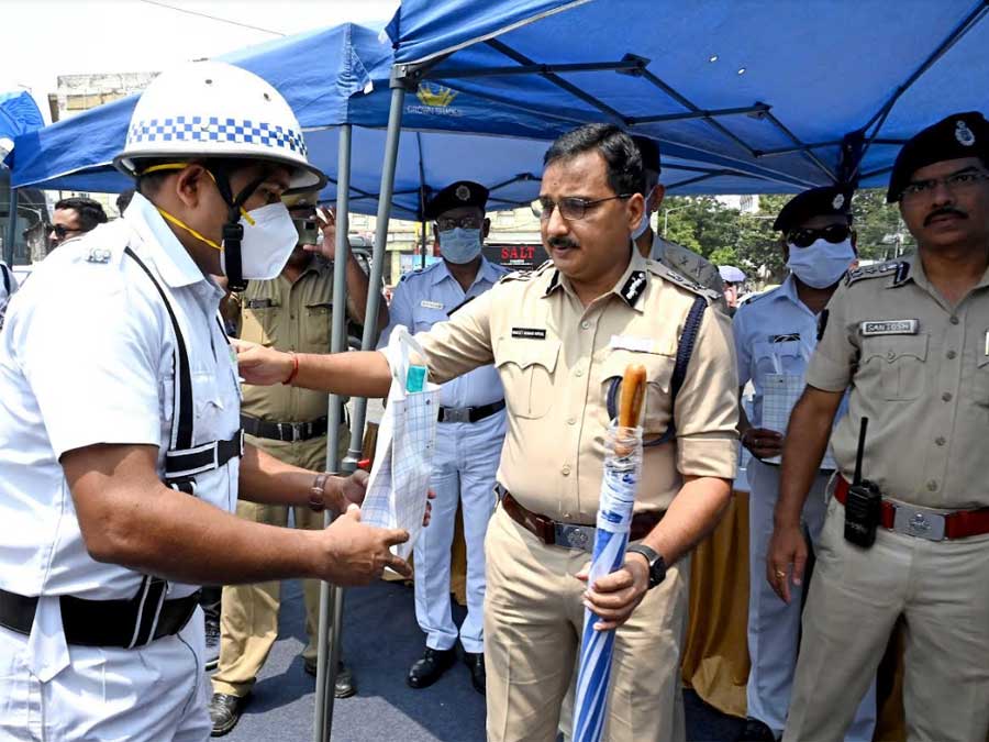 Kolkata police commissioner Vineet Kumar Goyal distributes water bottles, umbrellas and sunglasses among traffic police personnel at the Park Circus seven-point crossing on Thursday morning