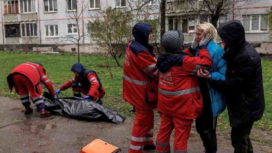 Crew members had to hold Yana Bachek back as they carried her father’s body away following the blasts that hit the Soviet-era apartment complex where they live.