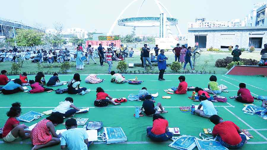 Children take part in a sit-and-draw contest for New Town residents on Sunday.