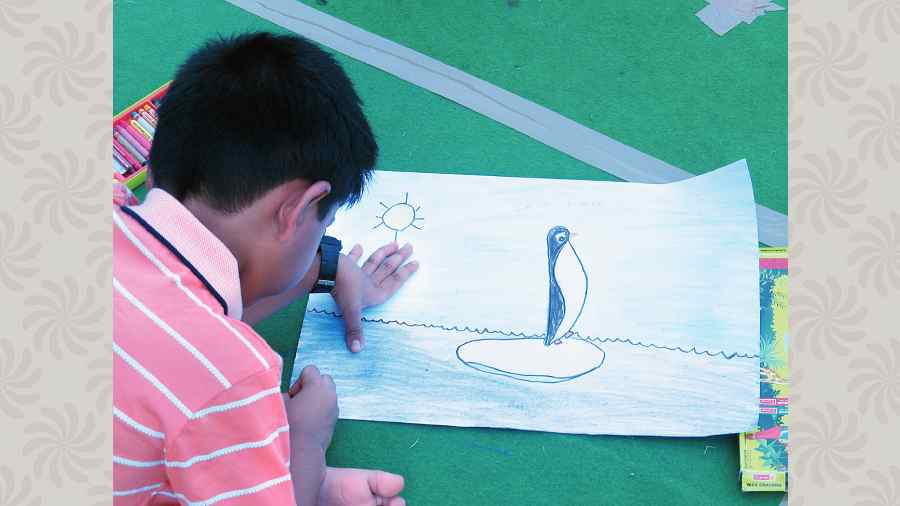 Swapnil Das, 5, paints a penguin. 