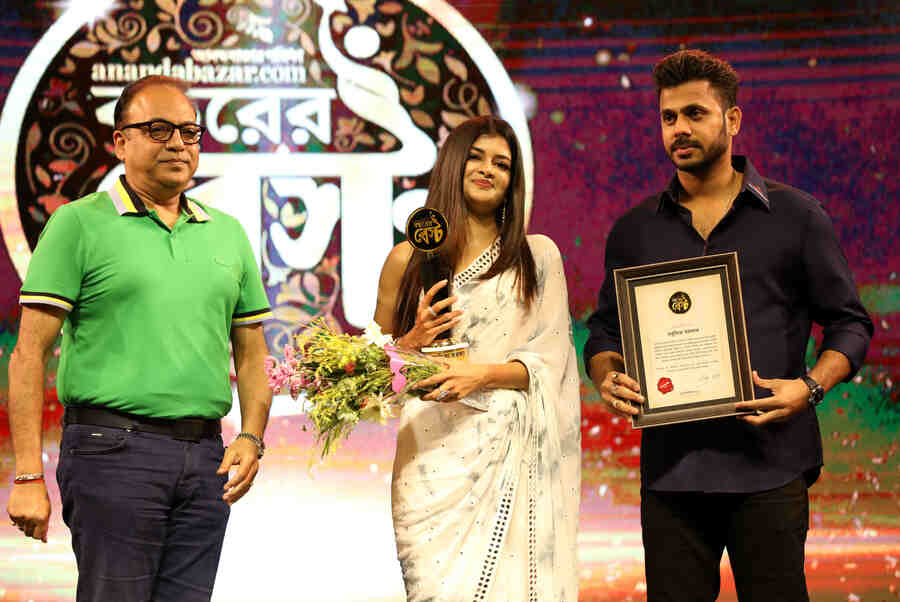 Arindam Sil and Manoj Tiwari hand over the ‘Bochhorer Best Ekadosh’ award to actress Madhumita Sarcar, who has given us memorable performances in Chini and Uttoron