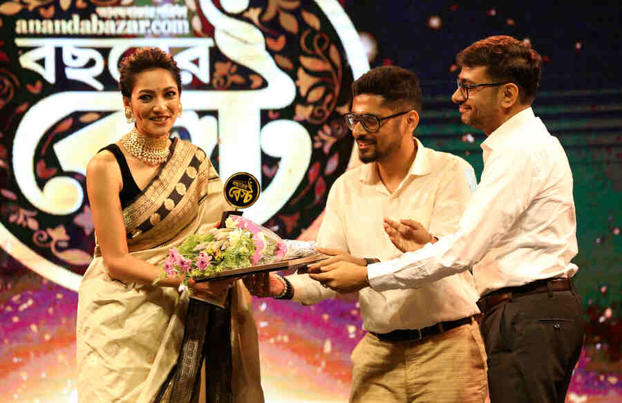  Actress Susmita Chatterjee, one of Tollywood’s brightest young talents, is presented with the ‘Bochhorer Best Ekadosh’ award by Hirak Bhattacharjee and Tilok Bhattacharjee