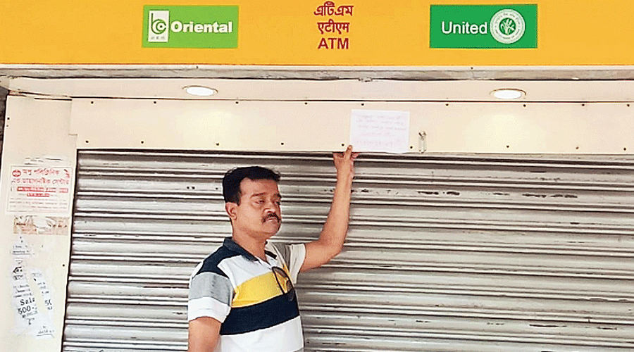 Chinmoy Chakraborty in front of the ATM counter in Mathabhanga town of Cooch Behar district on Sunday.
