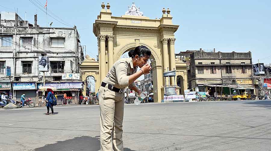 A police woman sprinkles water on the face in front of the Curzon Gate in Burdwan on Monday. 