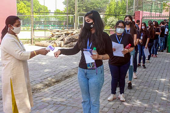 CBSE Class XII examinees undergo thermal screening before entering an examination centre in Gurugram.  