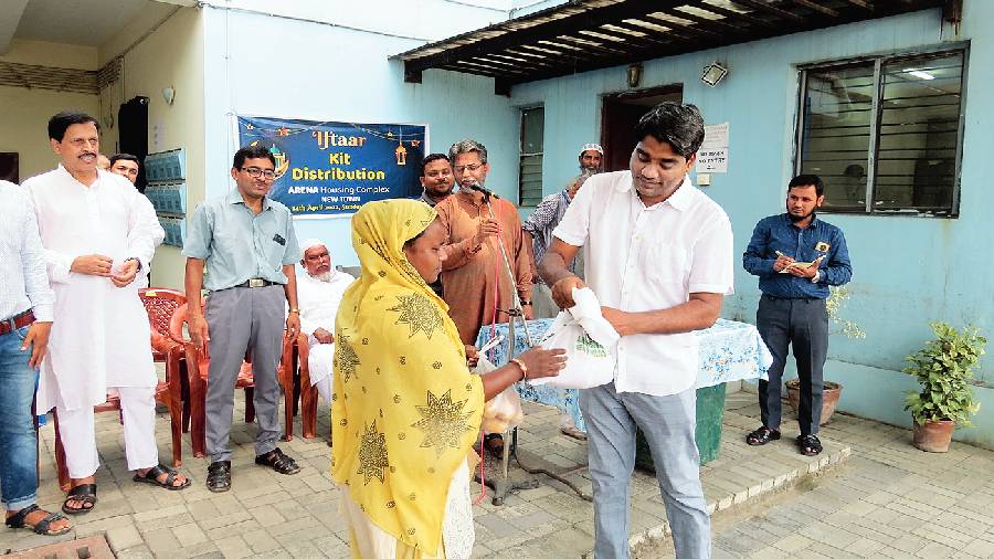 Iftaar kit being handed  over to a woman at Arena Housing Society in BA Block, New Town. 