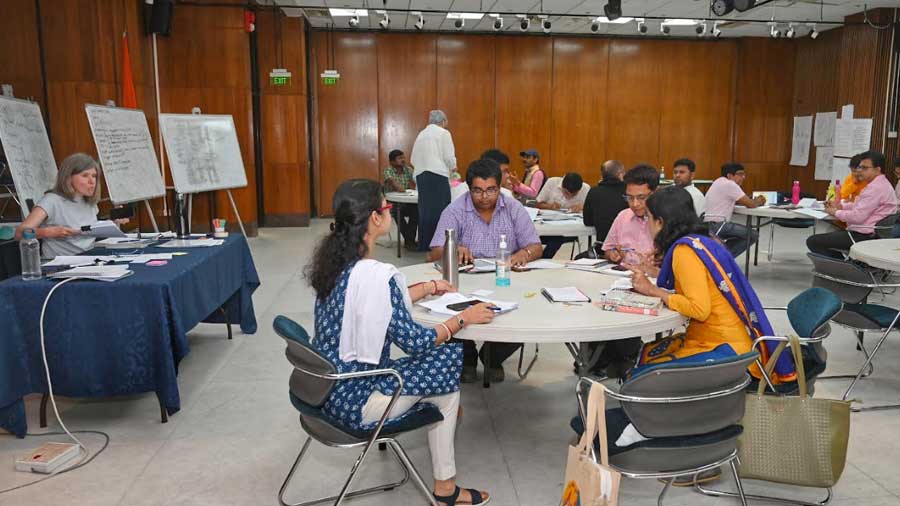 Participants, in small groups, engage with each other during a training task