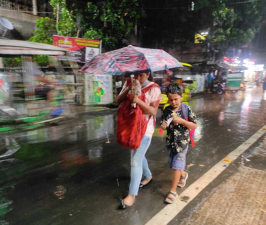RELIEF: A child and his guardian walk in the rain on Saturday, April 30. The city received its long-overdue shower on Saturday evening
