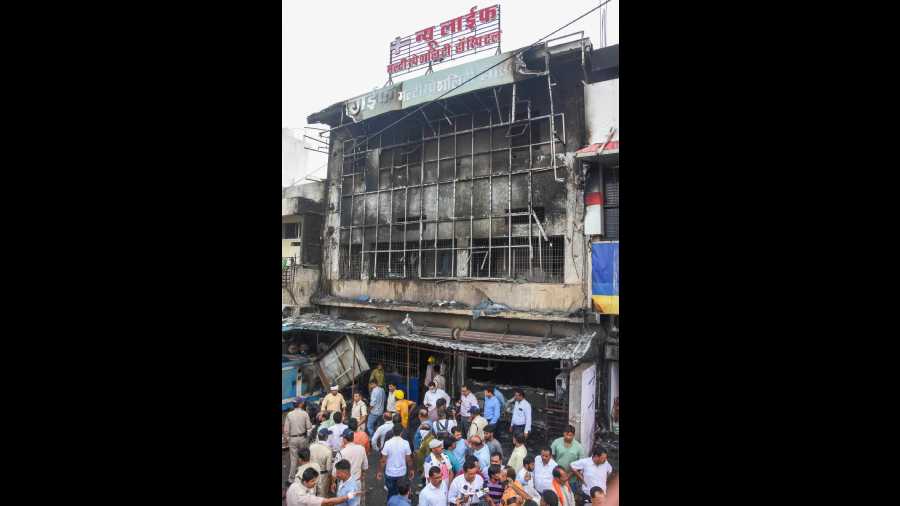 Locals gather at the site after a fire broke out at New Life Multi-speciality Hospital, near Damoh Naka in Jabalpur