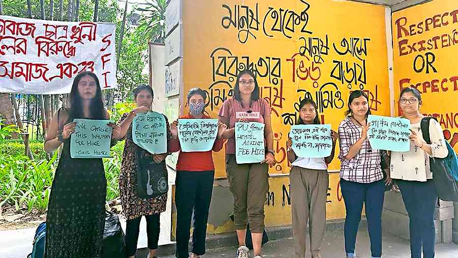 Students protest against the fee hike in hostel and discontinuance of the bus service on the university campus on Monday