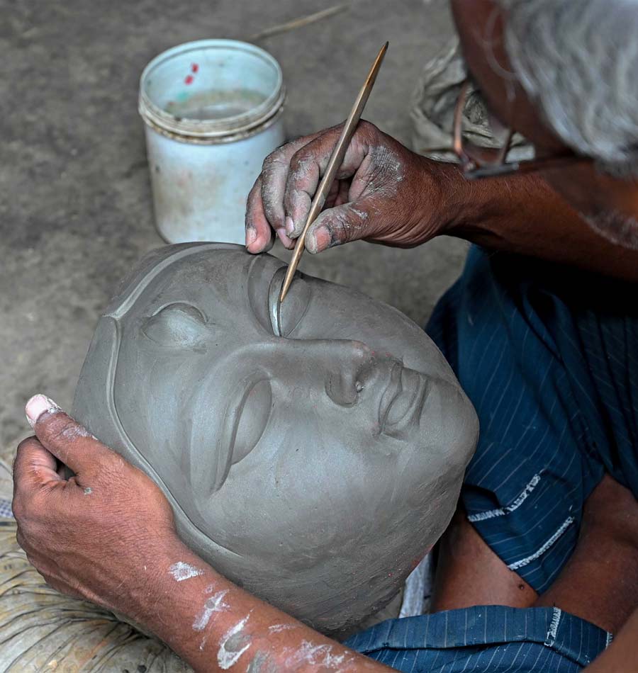 An artist gives shape to the eyes of an idol of goddess Durga on Tuesday 