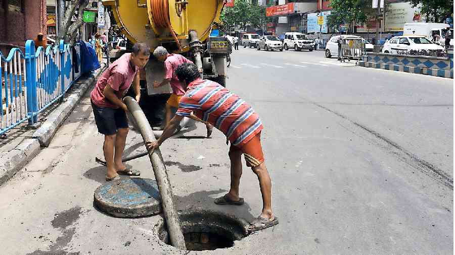 KMC workers clean a manhole along Chittaranjan Avenue on Thursday. 