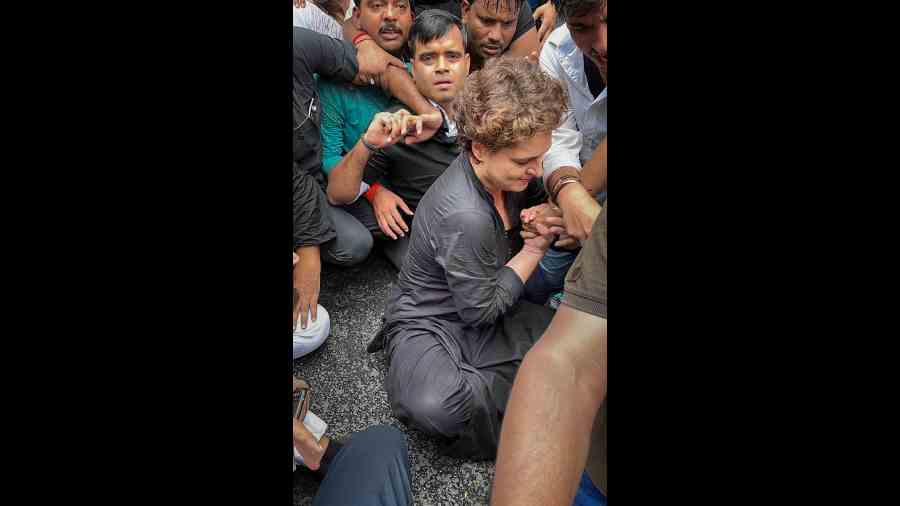 Congress leader Priyanka Gandhi, wearing black clothes, sits on the road during a protest march as part of party’s nationwide protest over price rise, unemployment and GST hike on essential items, in New Delhi