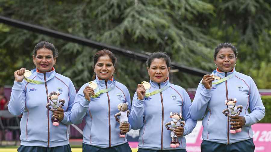 Lovely Choubey, Pinki, Nayanmoni Saikia and Rupa Rani Tirkey pose for photos during a presentation ceremony after winning the Lawn Bowls Women's Fours final match against South Africa