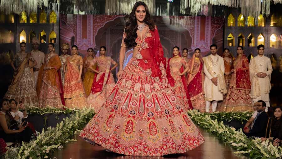 Nusrat walks the ramp in a scarlet Pallavi Poddar bridal lehenga