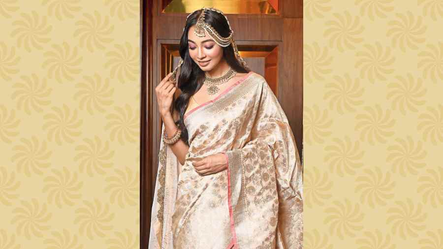 Bollywood weddings have always set trends and Alia Bhatt’s wedding was no different in that, inspiring millennials with the simple, elegant look in ivory. This fuss-free, minimal wedding look is perfect for the bride who wants to stick to the traditional Benarasi for the wedding but explore it in a contemporary way. The ivory Benarasi sari with golden detailing and a pretty peach border is accentuated with a golden tissue veil, designed with pearl-detailed scallops along the border. “Give the traditional red and maroon lehngas a miss and opt for something more contemporary and elegant like this,” suggested Pinki.