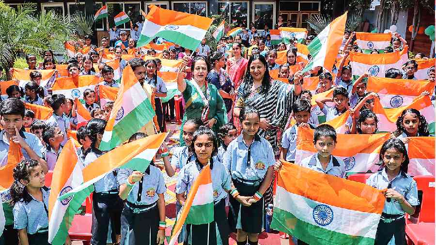 BJP MP Hema Malini distributes national flags among schoolchildren in her constituency Mathura on Wednesday. 