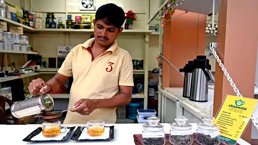 A staff member brewing tea for customers