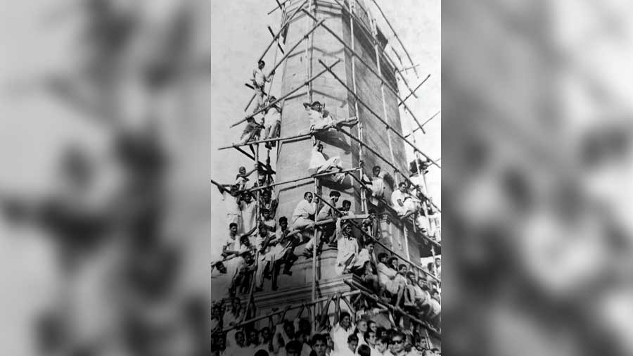 An old photograph from the 1960s showing spectators climbing the monument to watch football matches
