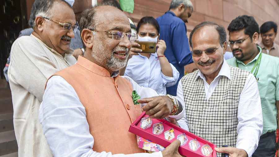 BJP MP Vijay Goel interacts with Congress MP Adhir Ranjan Chowdhury while distributing rakhis with pictures of freedom fighters at Parliament House complex during ongoing Monsoon Session