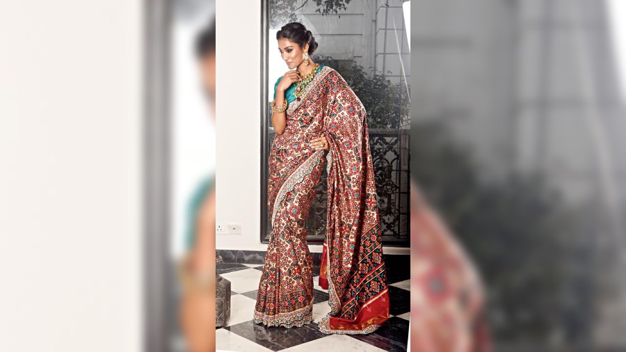 The ivory double ikat vegetable-dyed patola sari with micro mirror-work embroidered border and matching blouse is an offbeat and chic statement for a wedding function. Pair it with a polki necklace and earrings with chunky emeralds, polki pachelis and polki and ruby ring for a dose of extra glam. 