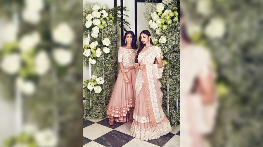 Tanisha De and Diti Saha look flirty-feminine in their nude tulles. While Tanisha rocks a nude tulle asymmetric dress with a thread and beadwork bodice paired with diamond chandelier earrings and stackable rings, Diti is lovely in a nude tulle layered kalidaar sari embroidered with a scalloped thread-and-beadwork border, matching blouse, diamond necklace, sapphire and diamond bangles and a diamond cocktail ring.