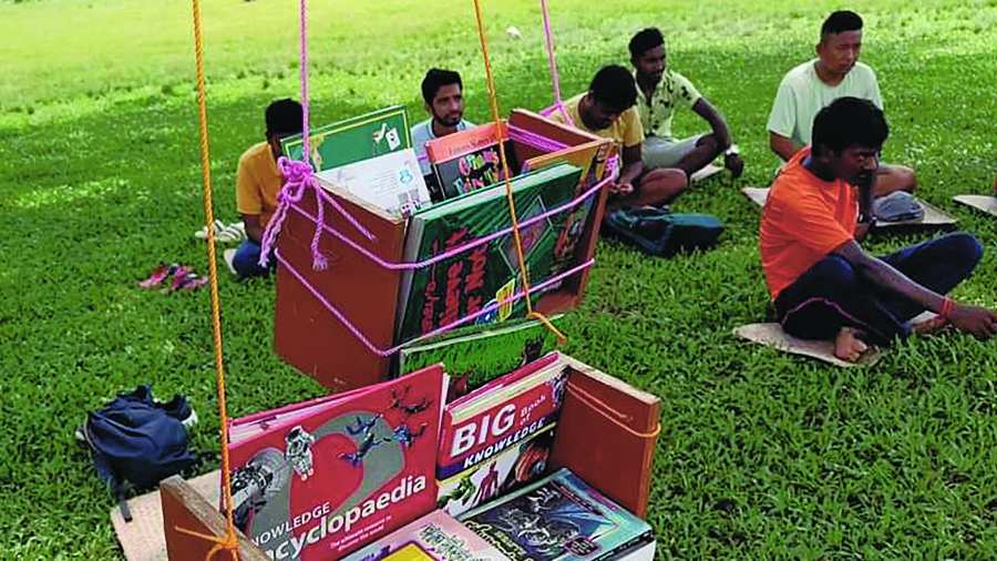 People gather on the European Club ground in Alipurduar to read books of the tree library on Sunday.