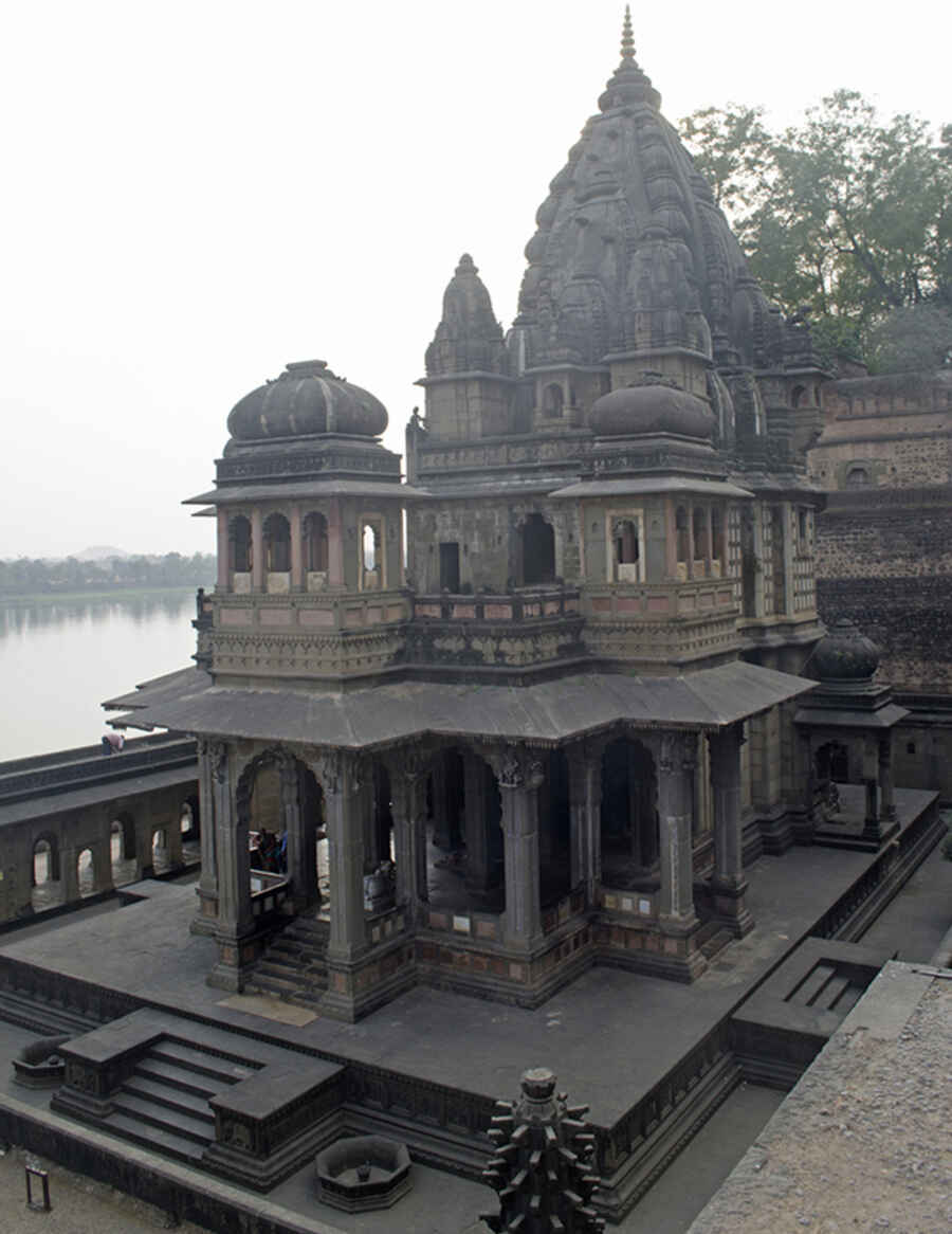 The larger of the two cenotaphs belong to Ahilya Bai and was commissioned by her daughter Krishna Bai. It is also known as Ahilyeshwar Shivalaya since the inner sanctum has a ‘shivalinga’, along with a statue of Ahilya Bai. The cenotaph is designed as a pillared ‘mandapa’ built in the Nagara style and stands on a raised platform with beautiful floral and geometric friezes on its side. Its towering black curvilinear tower is capped with a brass finial