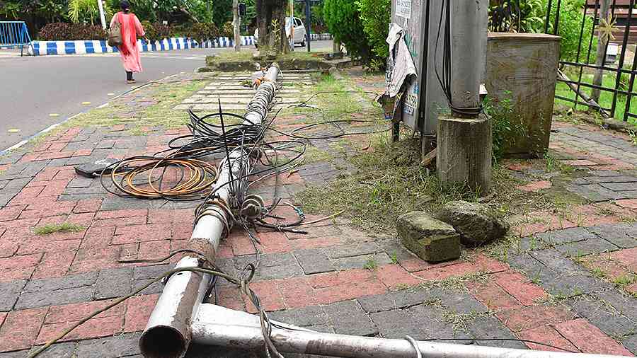 A cable-laden post lies on the pavement opposite the FD Block park.