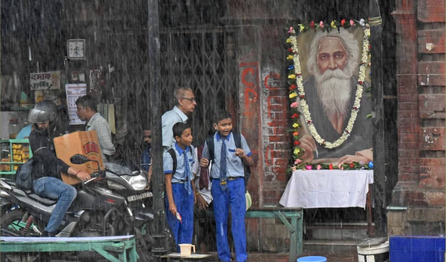 Schoolboys in front of a garlanded picture of Rabindranath Tagore on Beadon Street on the poet’s death anniversary.
