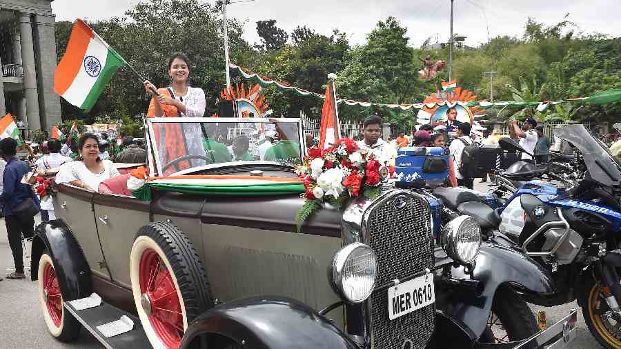 People aboard a vintage car take part in bike rally on the occasion of the 75th Independence Day celebrations, in Bangalore. 