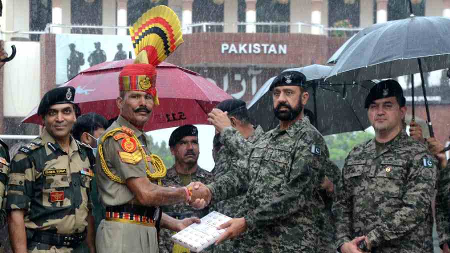 Border Security Force and Pakistani Rangers personnel exchange sweets on the occasion of India's 75th Independence Day celebrations at the India-Pakistan Attari-Wagah border. 