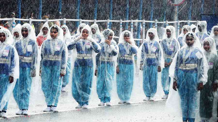 Schoolchildren perform at the Independence Day parade on Red Road amid rain.