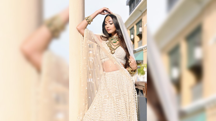 Going by the popular Bollywood wedding trends, the present wedding day look is all about ditching the traditional red and maroon and opting for the contemporary favourite shades of ivory and white. The intricately woven outfit from Seema Gujral is glammed up with the trendy layering-style polki jewellery and balanced out with de-glam make-up and the hair comfortably worn open.