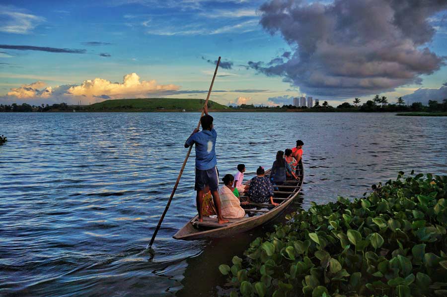 A dinghy sets out with passengers in the East Kolkata Wetlands on Wednesday evening.